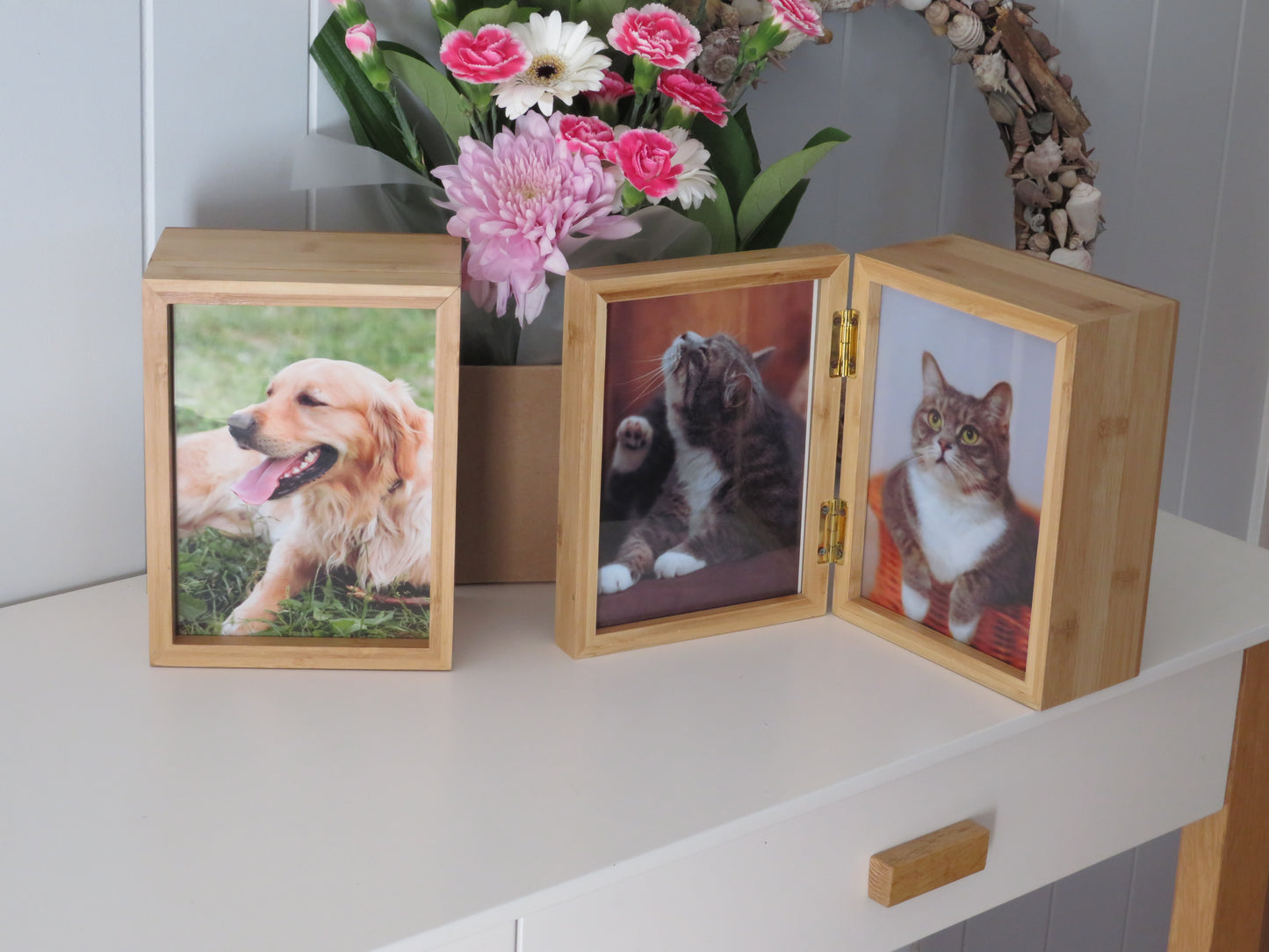 two bamboo photo box urns with photos of cats and dog standing on a table