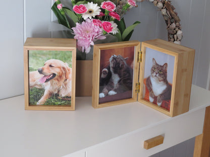 two bamboo photo box urns with photos of cats and dog standing on a table