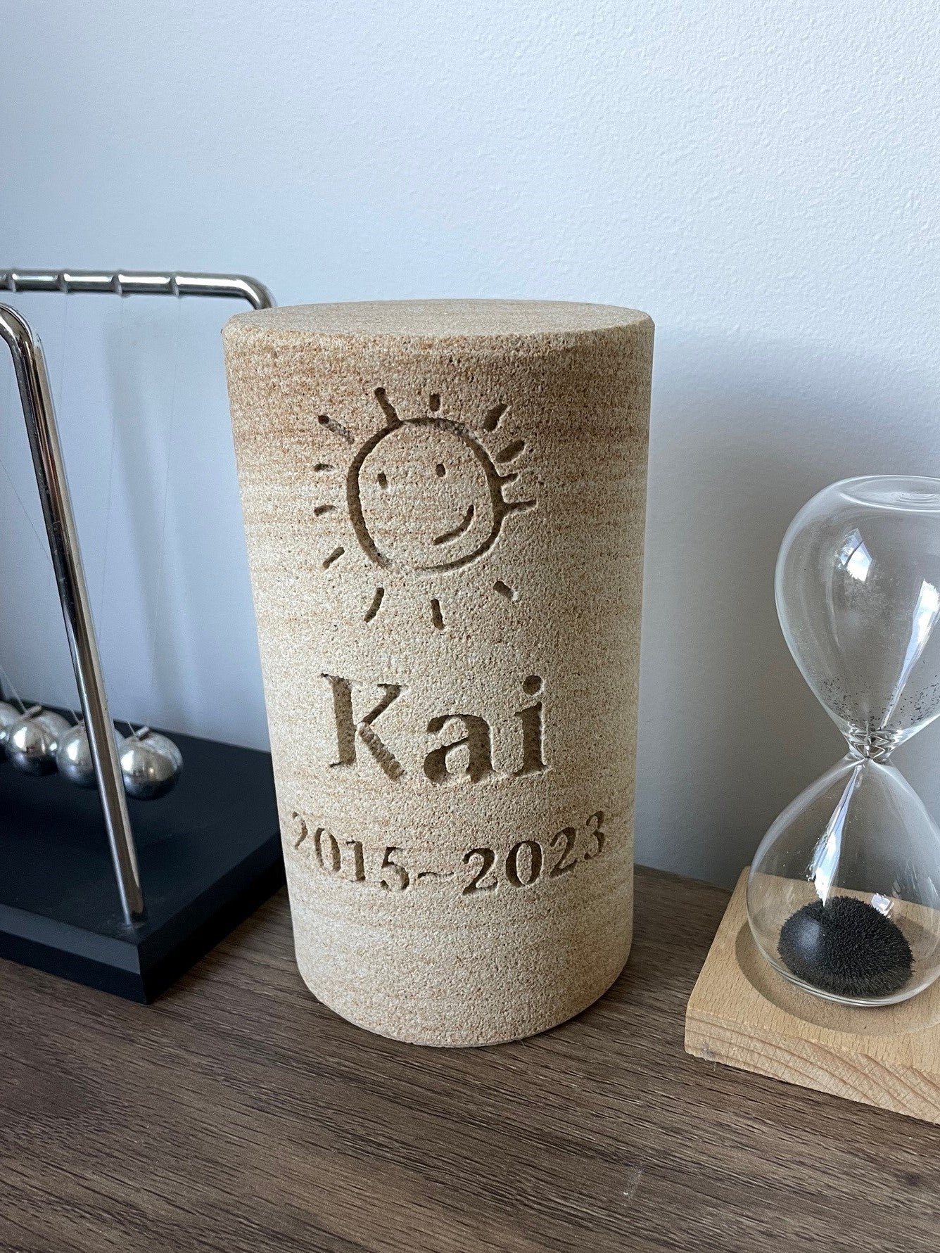 ENGRAVED SANDSTONE CYLINDER URN WITH A MEMORIAL INSCRIPTION FOR A PERSON