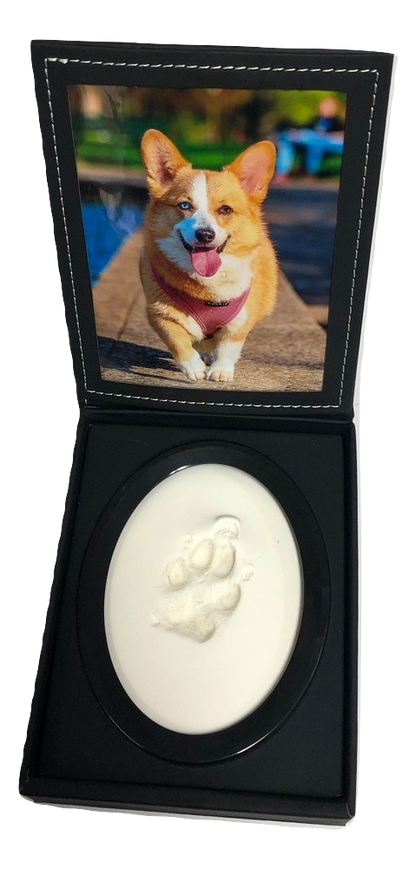 A display case with a photo of a dog and a paw print impression in clay