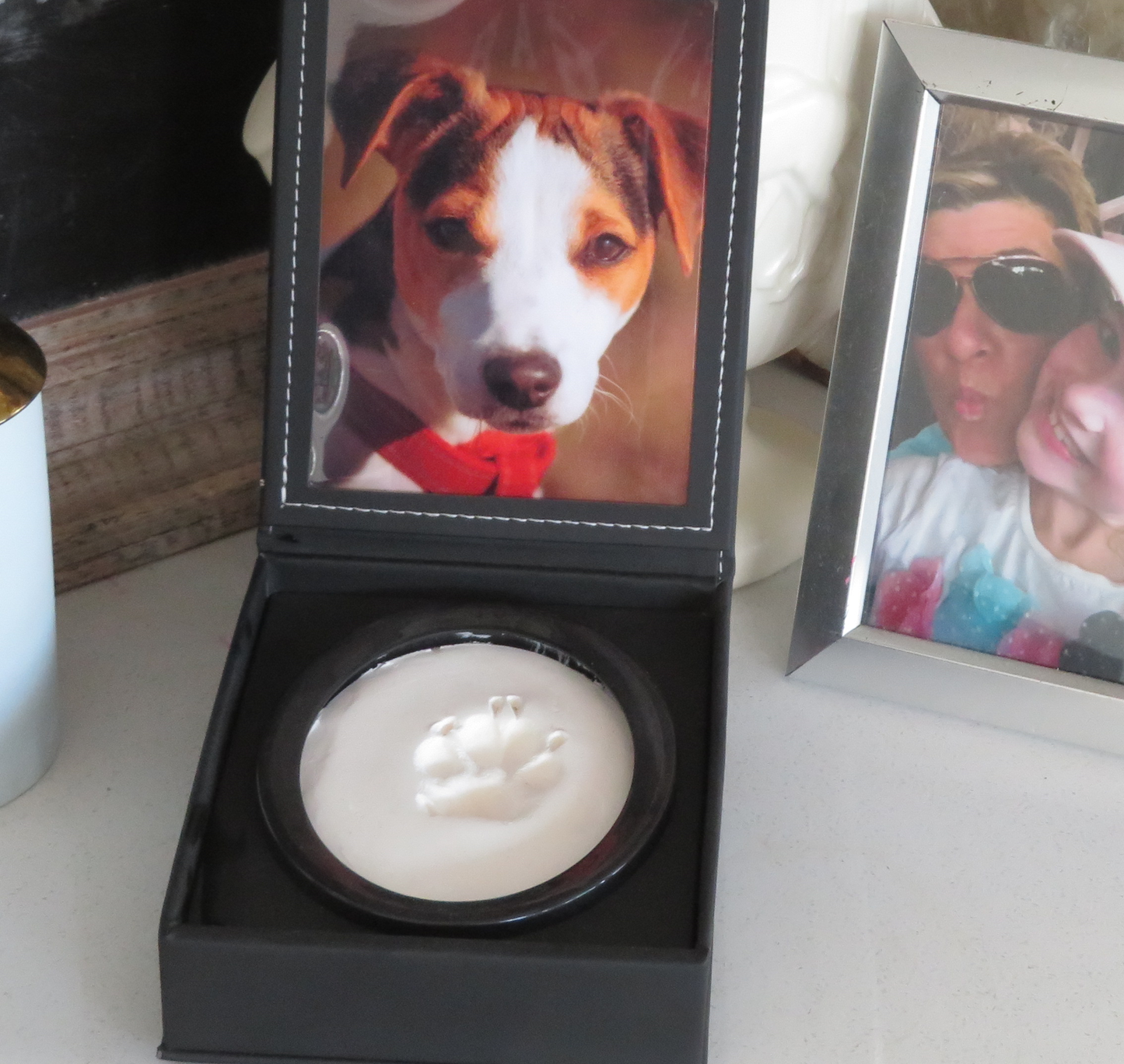 A display case with a photo of a dog and a paw print impression in clay